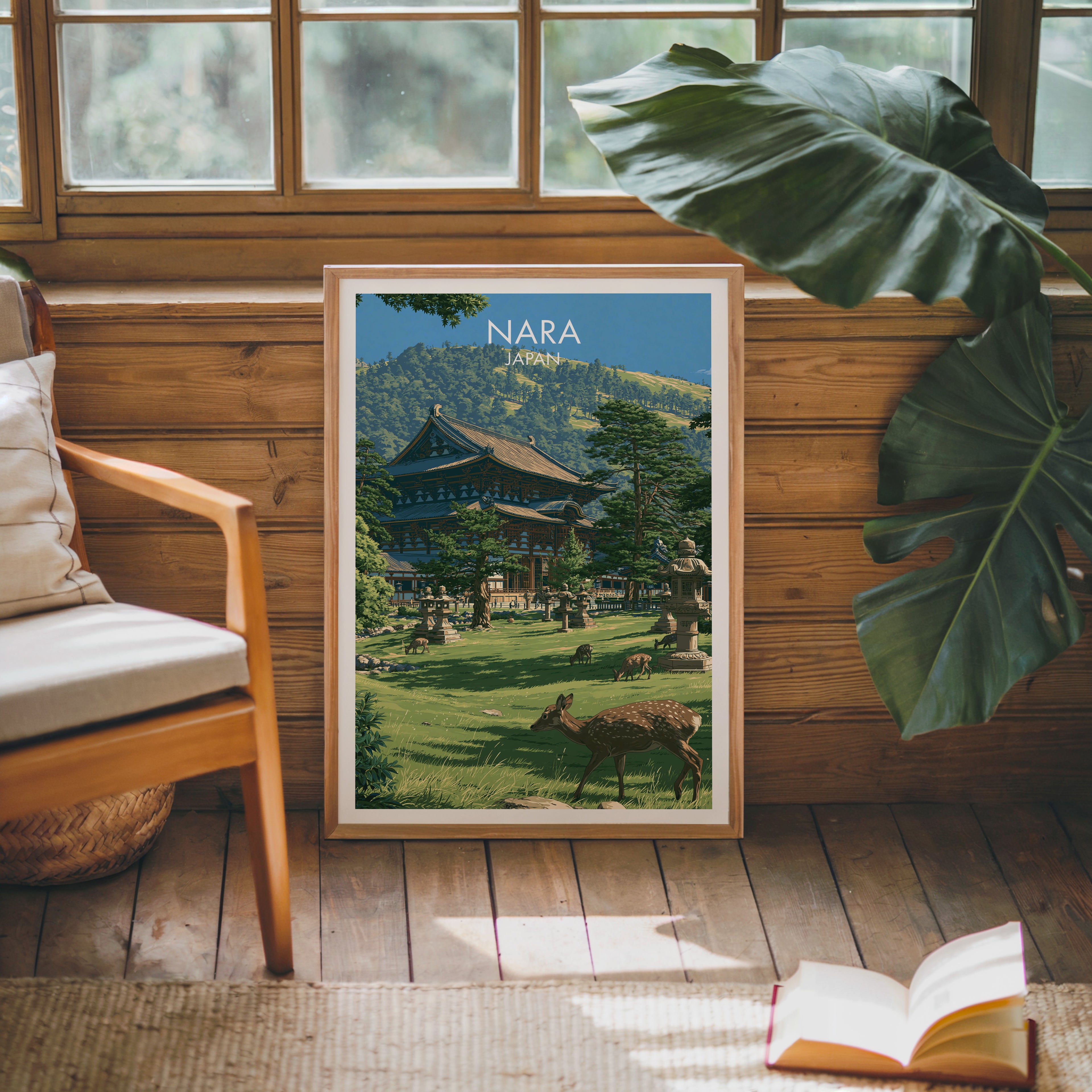 Framed Todai ji Temple Nara Japan poster leaning against a timber cabin wall with monstera leaves and an open book
