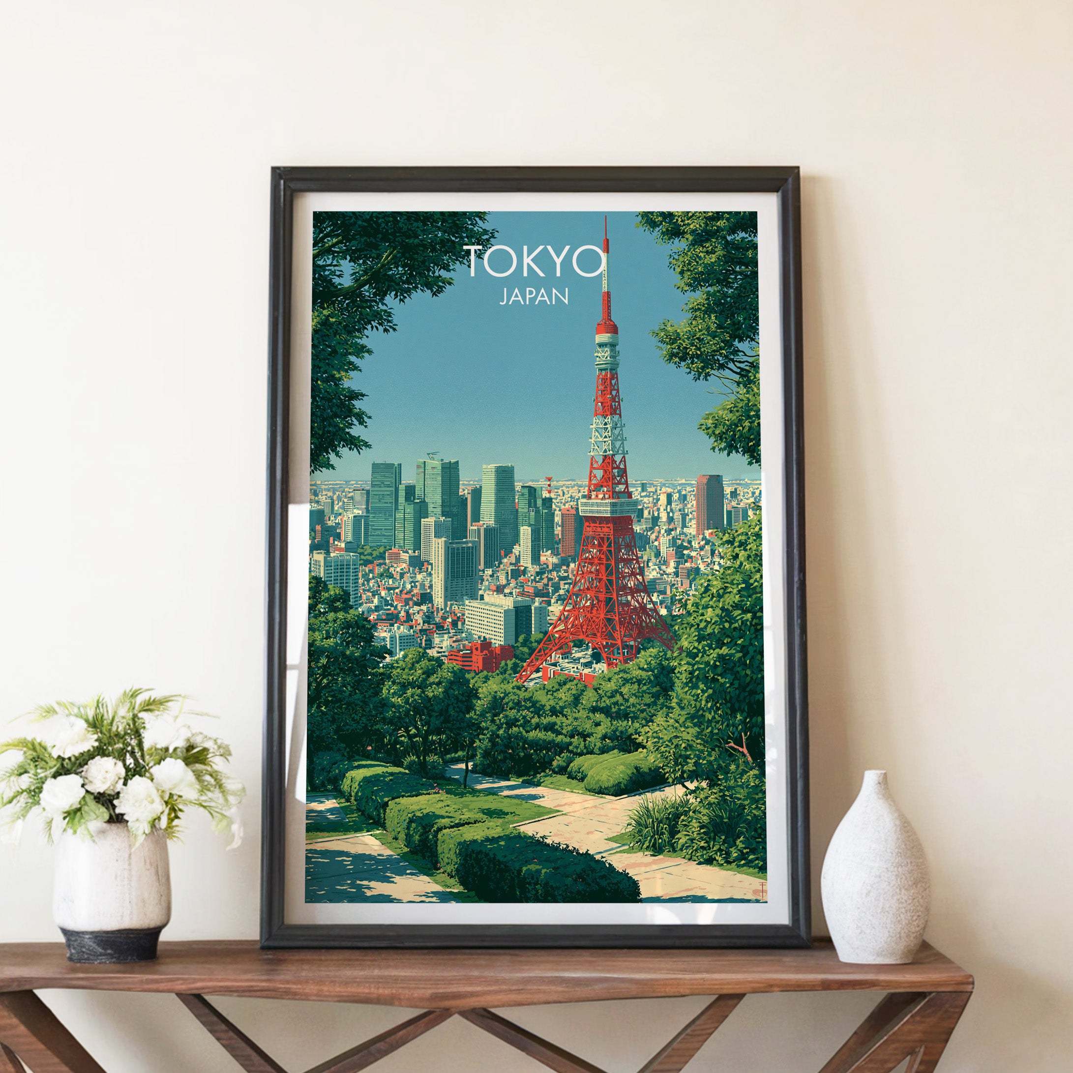 Tokyo Tower Japan travel poster in a black frame on a wooden console table with white flowers
