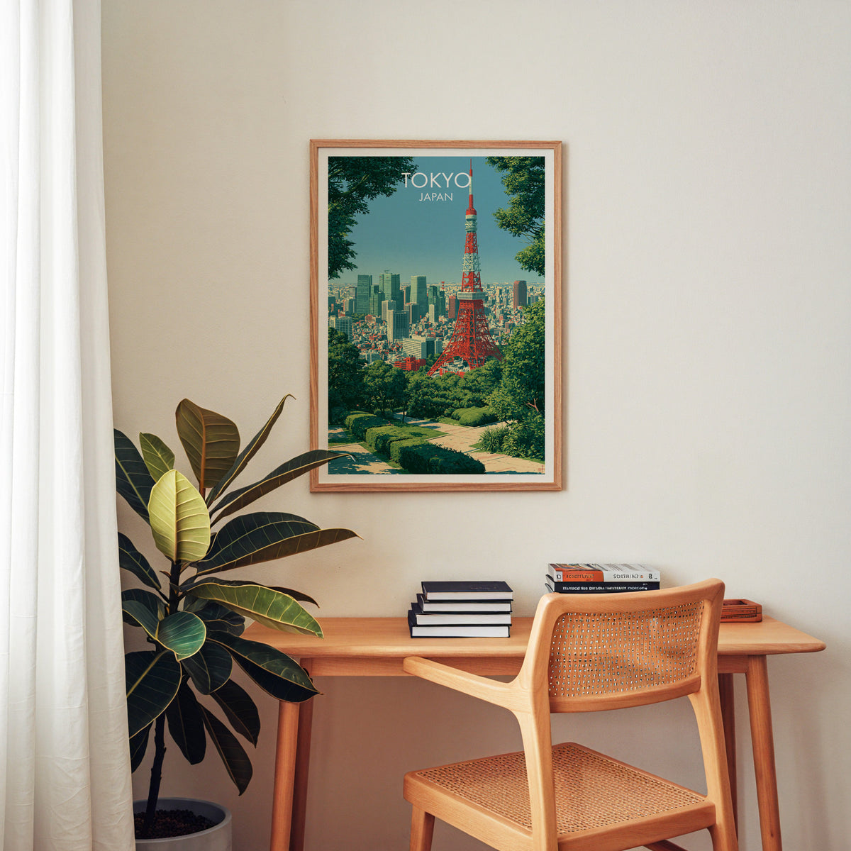 Tokyo Tower art print in an oak frame above a wooden home office desk with a cane chair and books