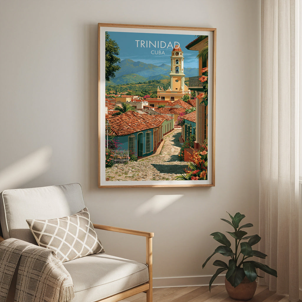 Colonial lane scene in an oak frame above a cream armchair with a check cushion, sheer curtain and rubber plant