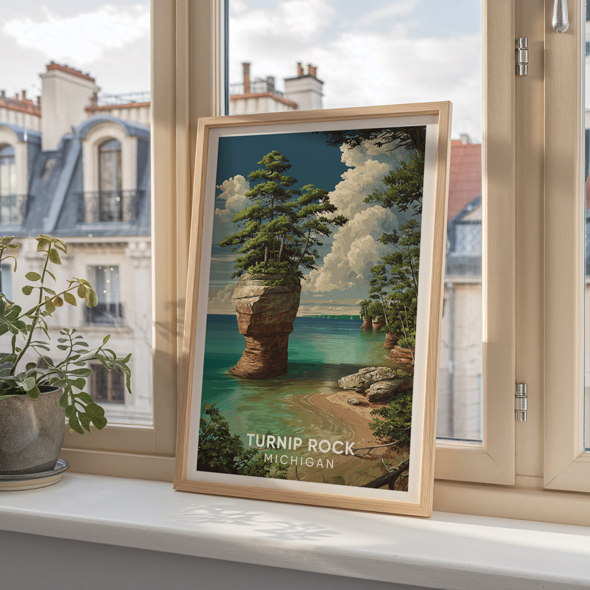 Turnip Rock poster in an oak frame on a windowsill with Parisian mansard roofs beyond the glass.