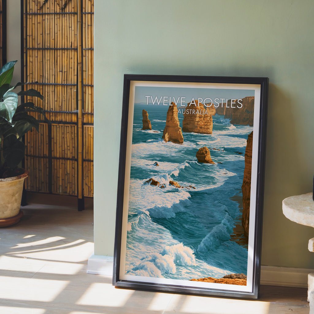 Victoria coast print in a black frame leaning on pale wood floor by a sage green wall and bamboo screen