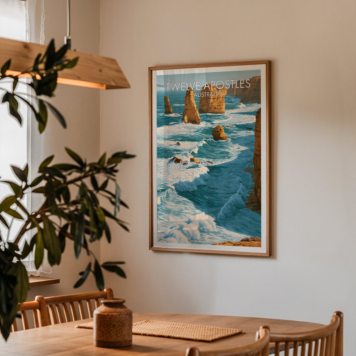 Twelve Apostles poster in an oak frame in a dining corner with spindle chairs and a wood pendant light