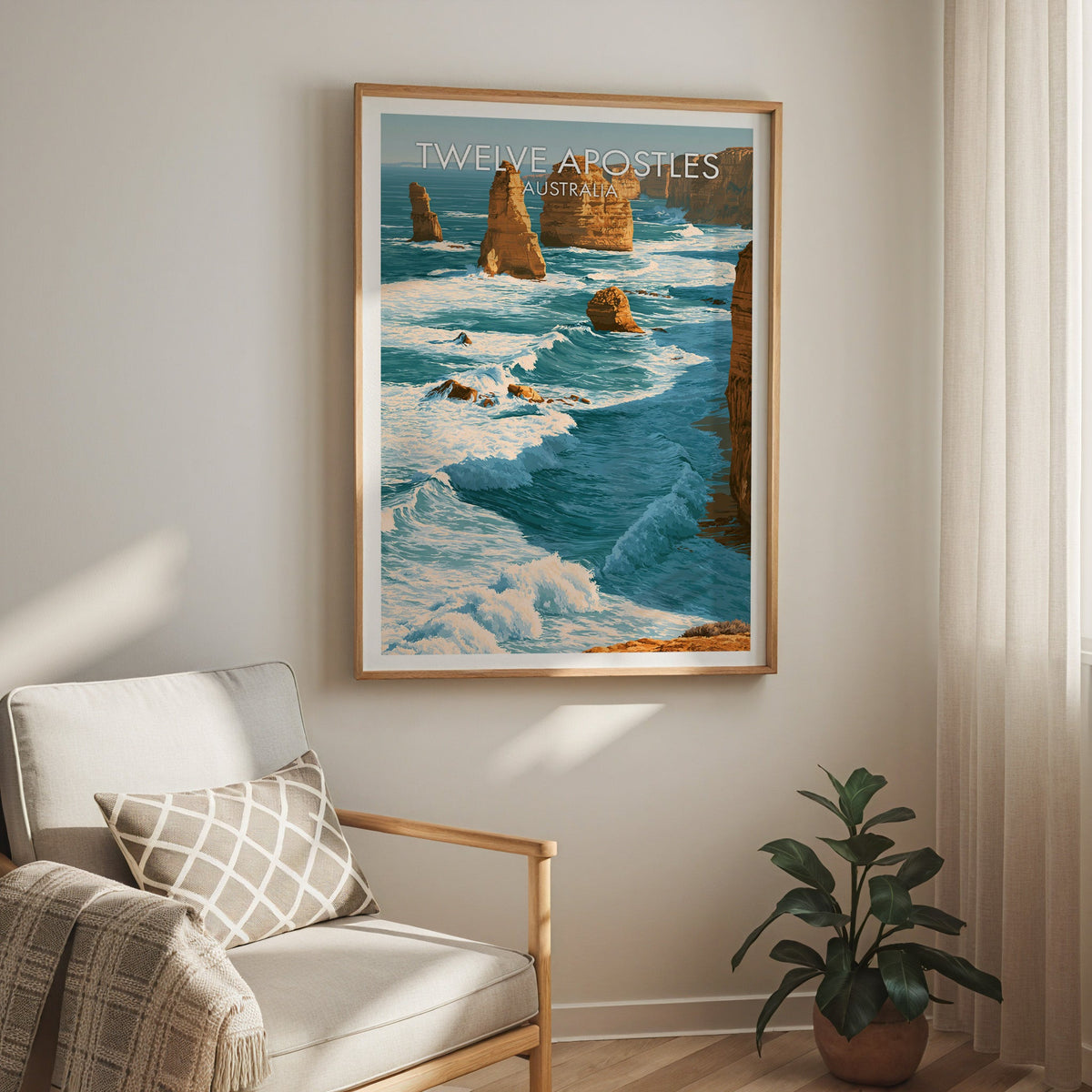 Limestone coast print in an oak frame above a cream armchair with a sheer curtain and a rubber plant