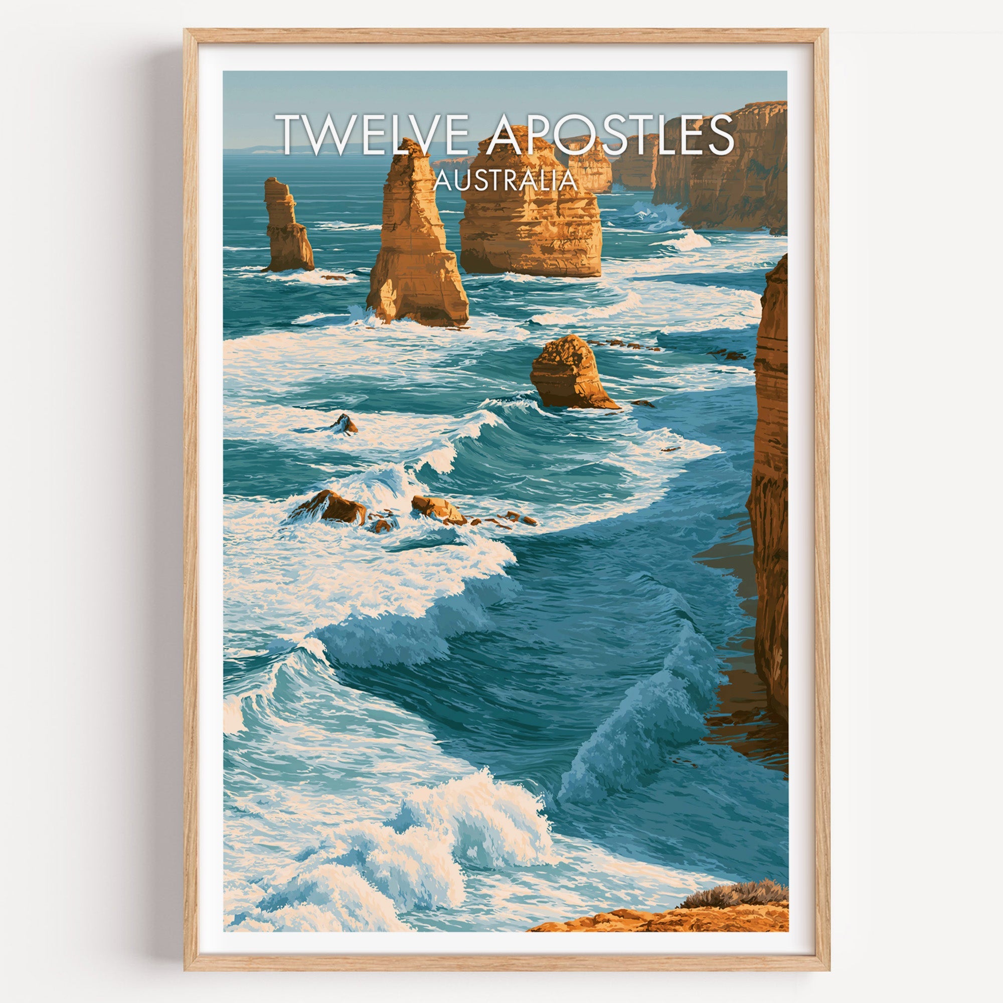 Twelve Apostles travel print in a light oak frame on a plain white wall