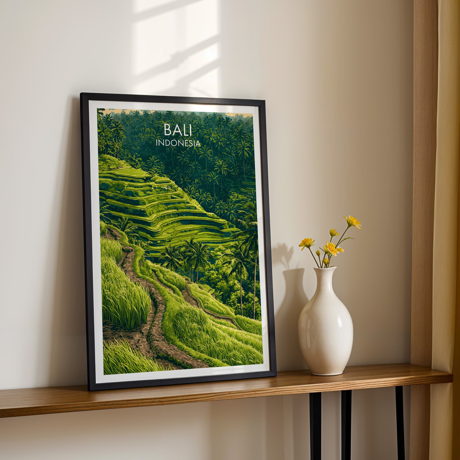 Black framed Ubud Rice Terraces Bali print on a narrow hallway console in sunlight, styled with yellow flowers
