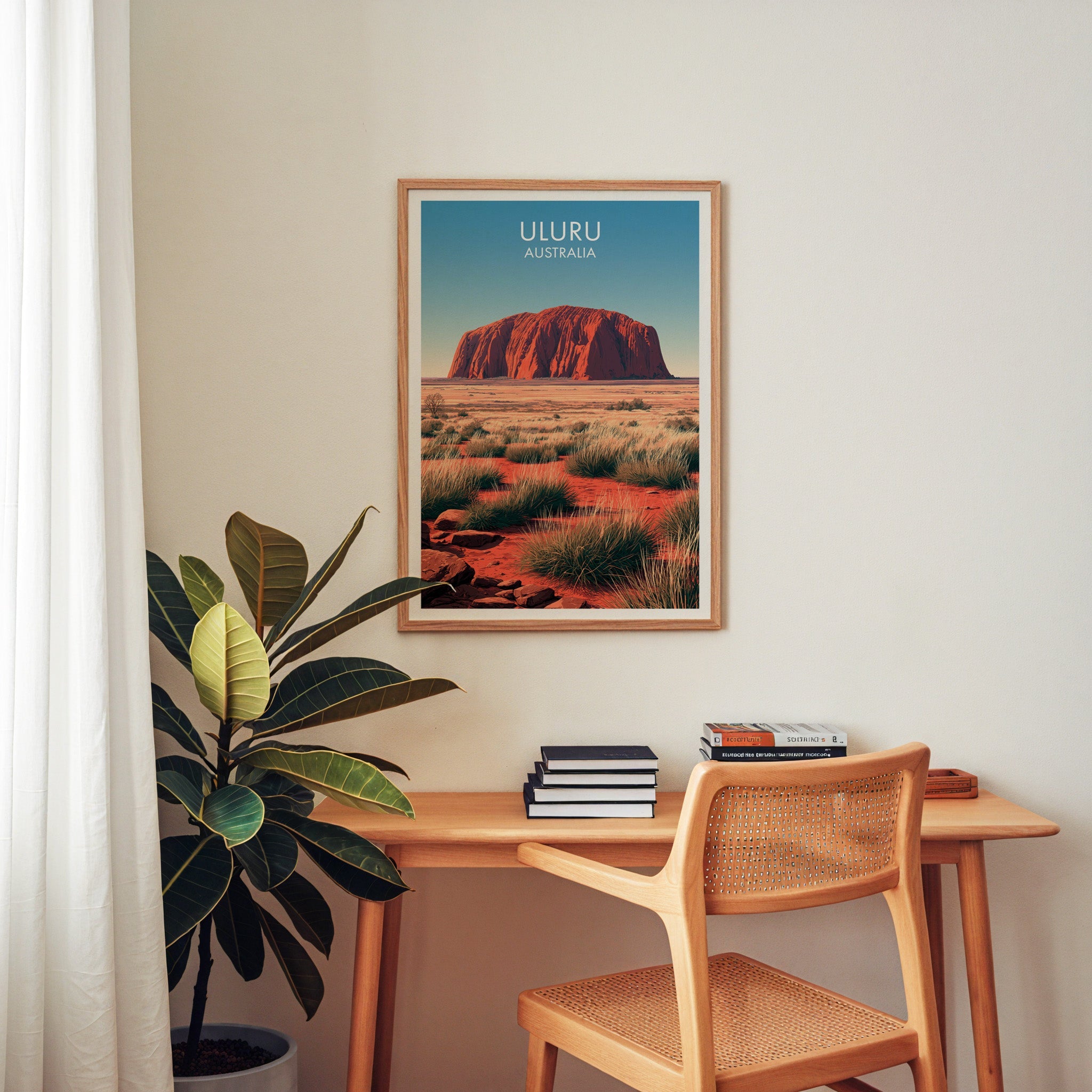 Outback landscape artwork in an oak frame above a home office desk with a cane chair and rubber plant