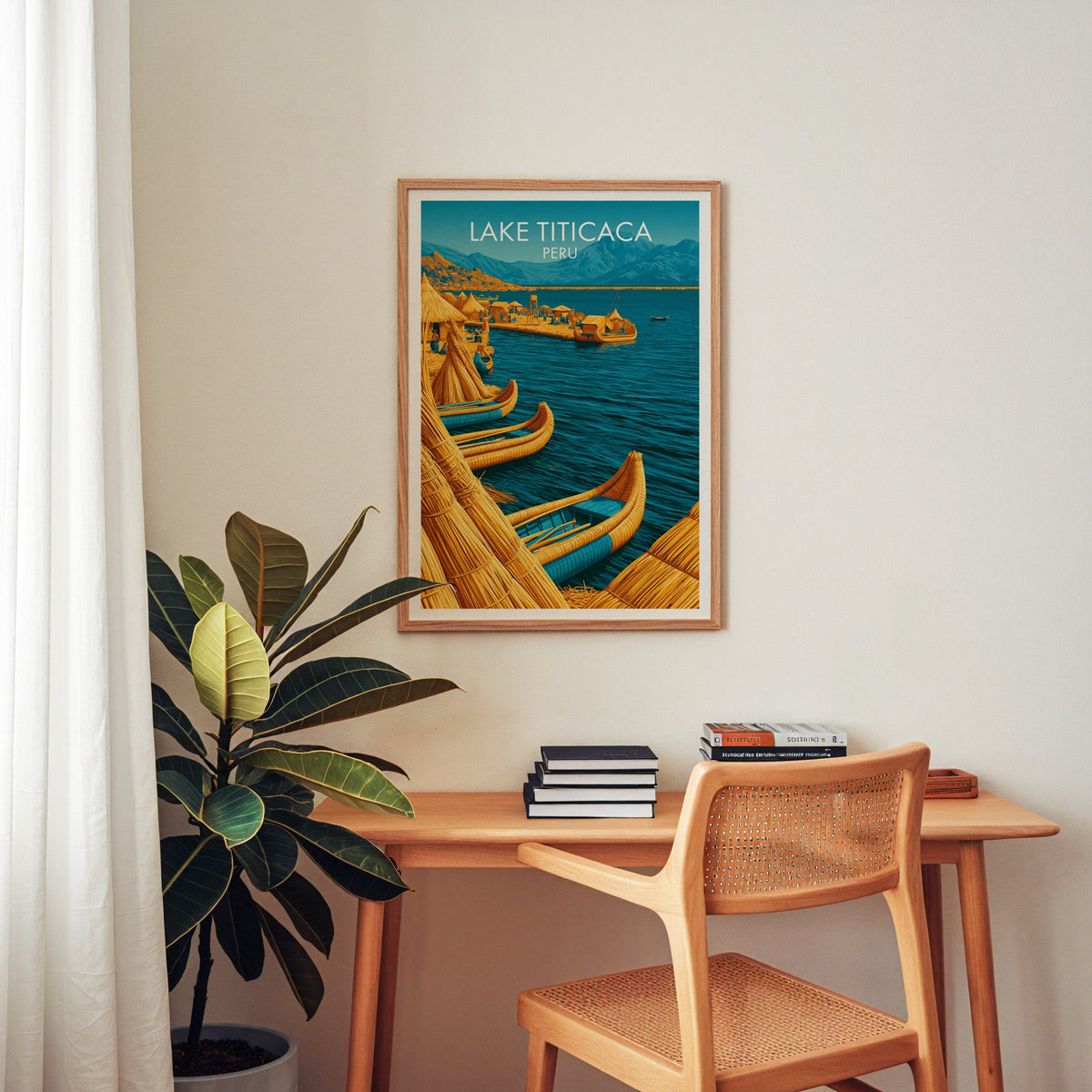 Titicaca Peru print in an oak frame above a wooden desk with a cane chair, stacked books and a plant