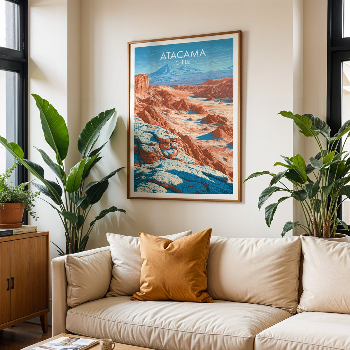 Valle de la Luna print in an oak frame over a cream sofa with rust cushions and two tropical plants