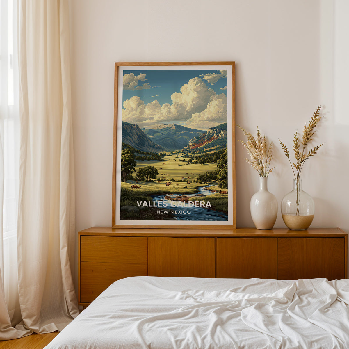 Valles Caldera print framed in oak on a teak sideboard by a bed with dried pampas in white vases.