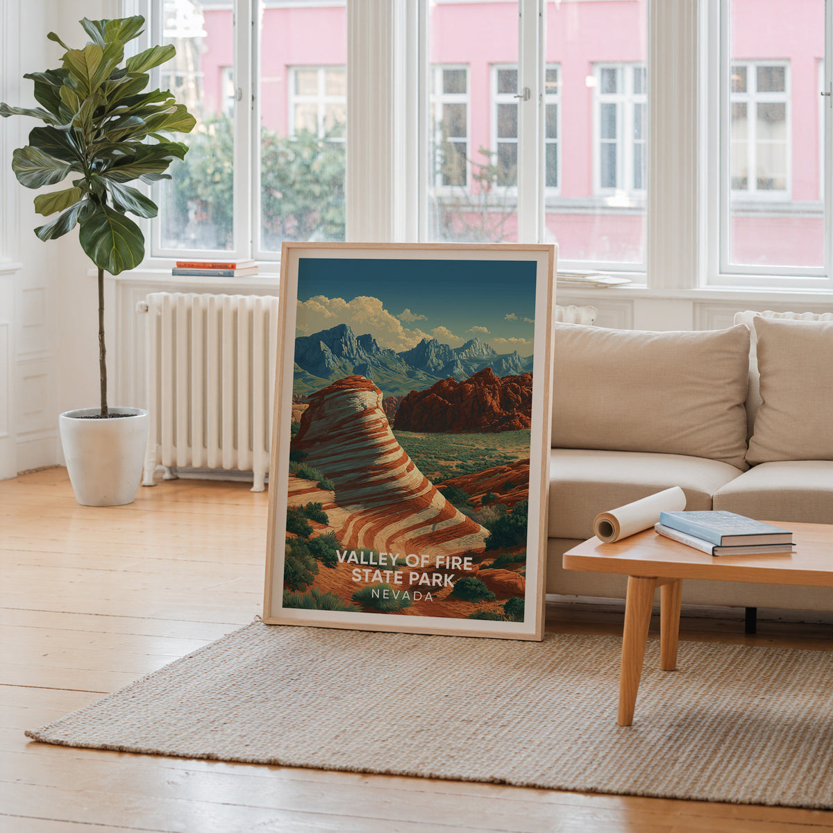 Desert rock travel poster leaning by a window looking onto a pink building, cream sofa and thick rug