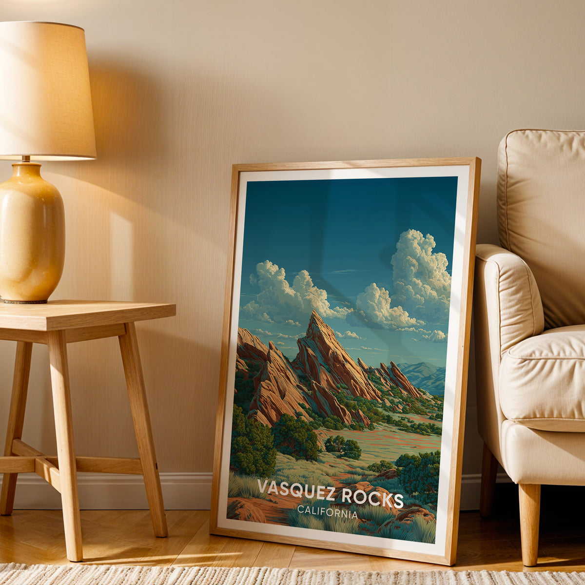 Vasquez Rocks artwork leaning beside a cream armchair and a wood side table with a terracotta lamp