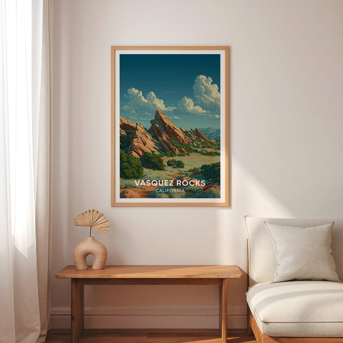 California travel print framed in oak above a slim wood bench with a cream armchair and sheer curtain