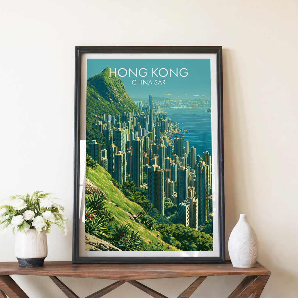 Victoria Peak Hong Kong travel poster in a black frame on a wooden console table with white flowers
