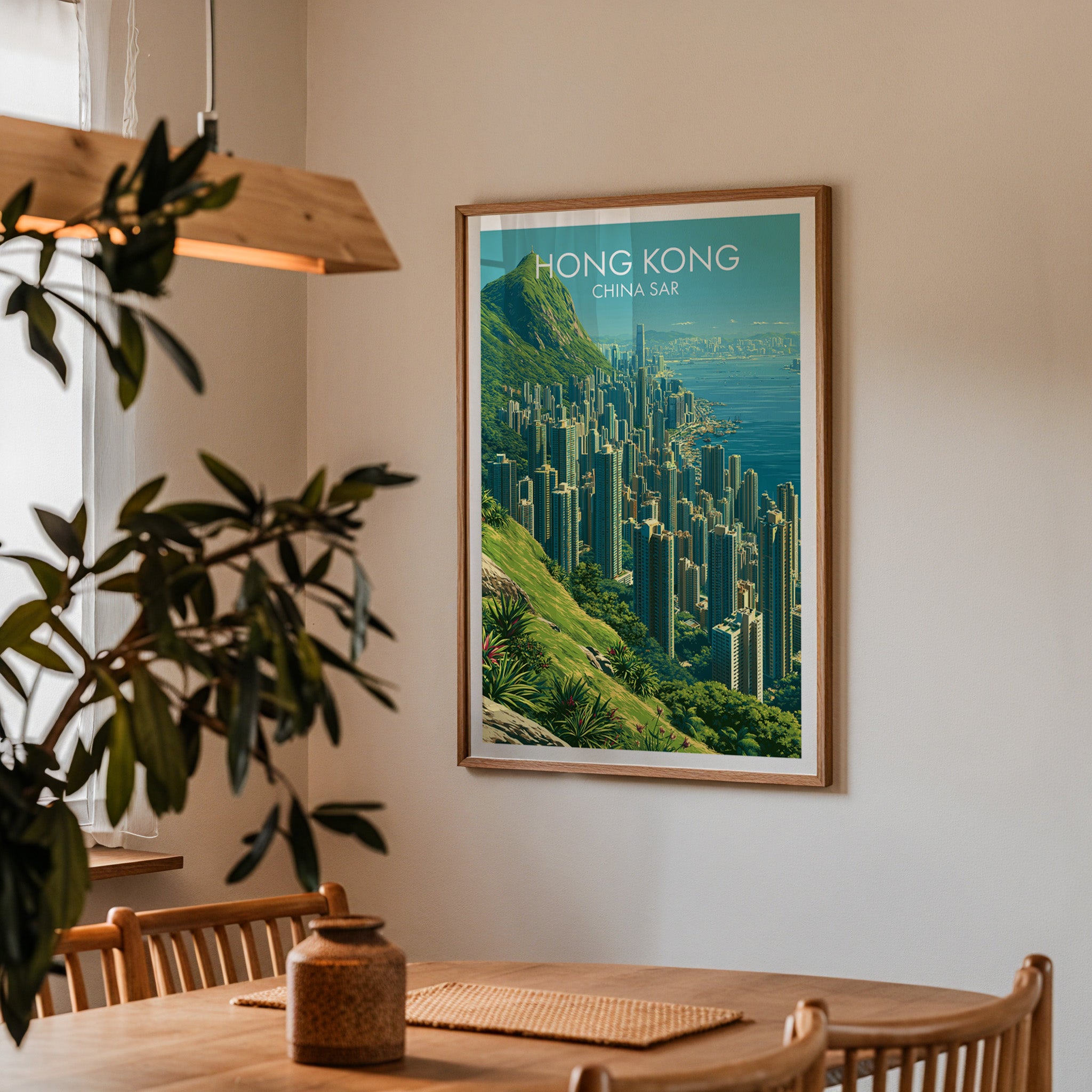 Framed Victoria Peak Hong Kong print on a dining room wall above an oak table in warm afternoon light