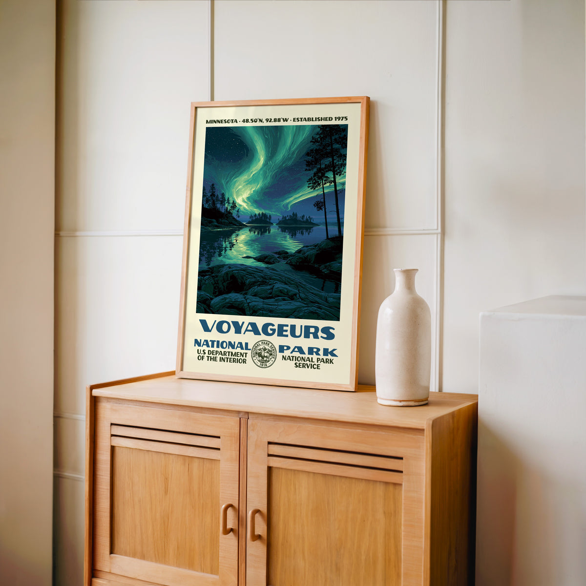 Voyageurs National Park WPA print framed in light oak on a wooden sideboard with a ceramic vase
