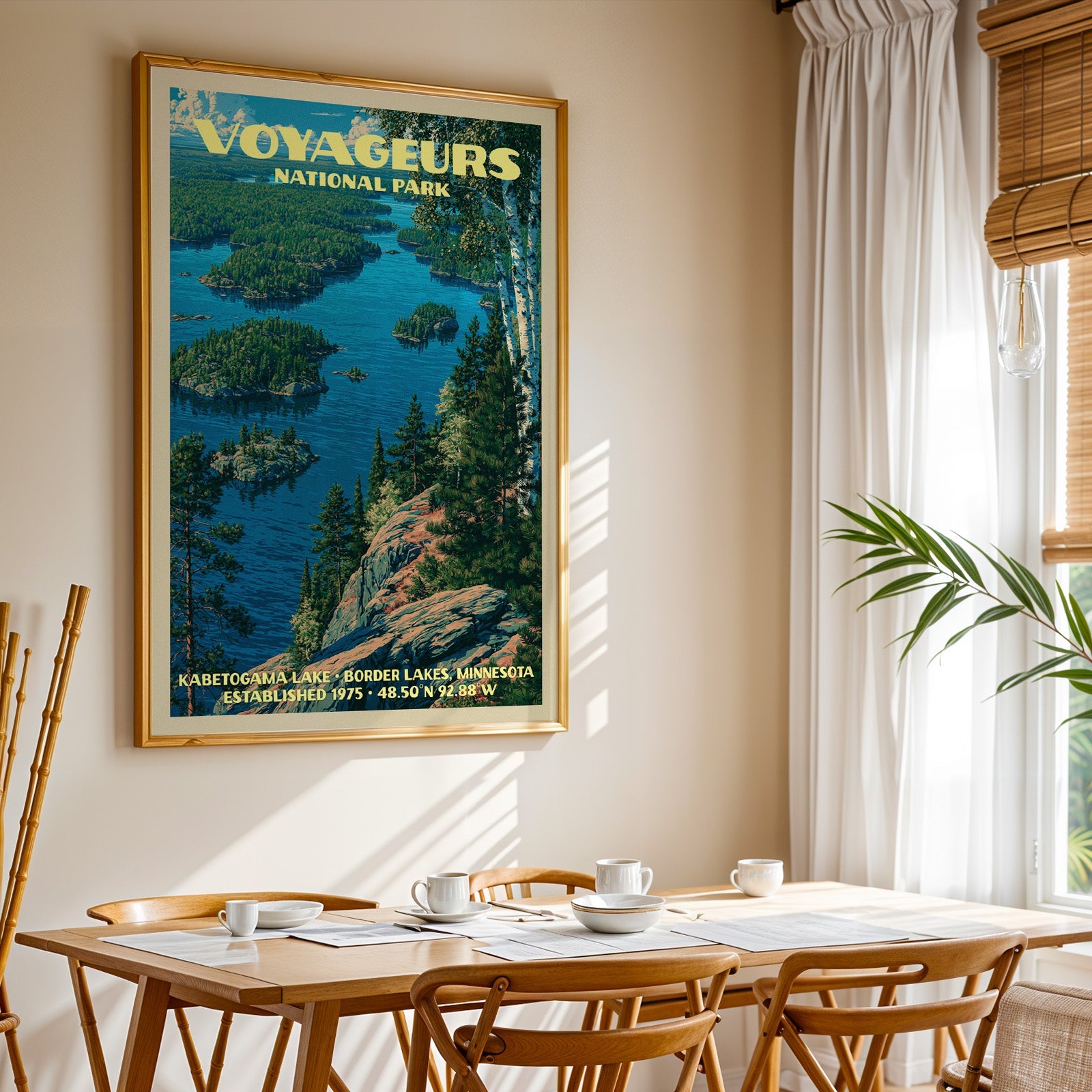 Voyageurs National Park print in gold above a light oak dining table by a curtained window
