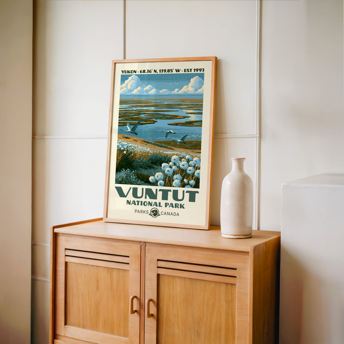 Vuntut National Park wall art, Yukon in an oak frame on a light wood cabinet beside a stoneware vase