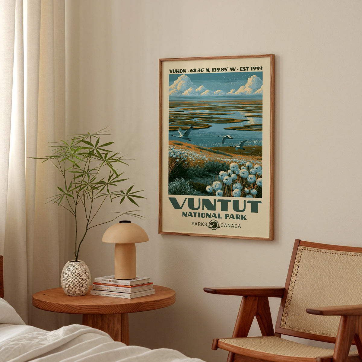 Vuntut National Park poster with flying swans in an oak frame above a bedside table with a mushroom lamp