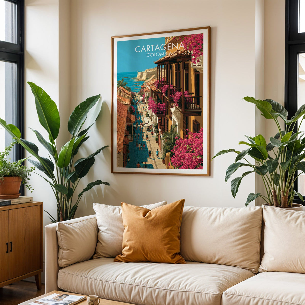 Bougainvillea street wall art in an oak frame above a cream sofa with rust cushions and two tropical plants