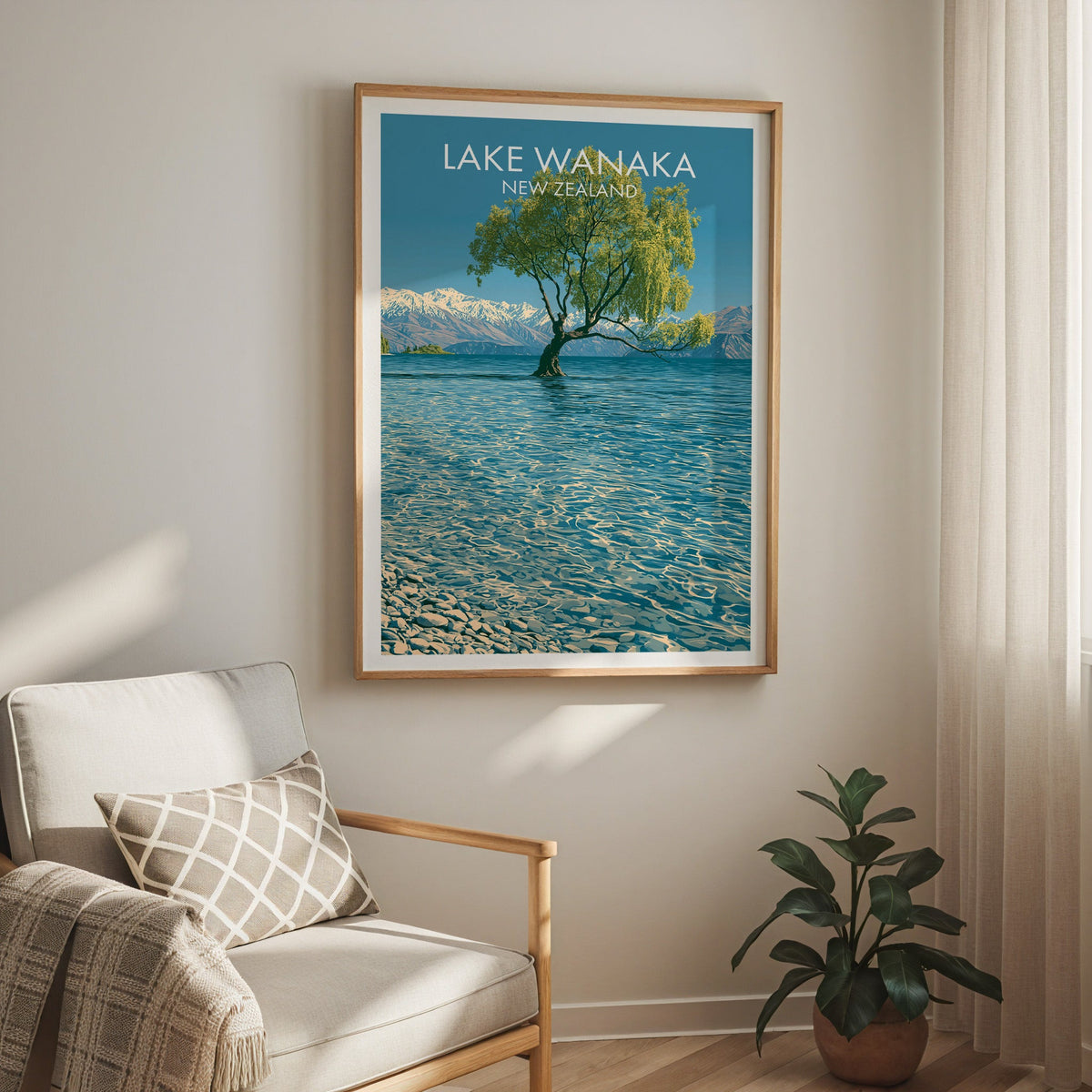 Lake Wanaka print above a cream armchair with a sheer curtain and a rubber plant in a terracotta pot