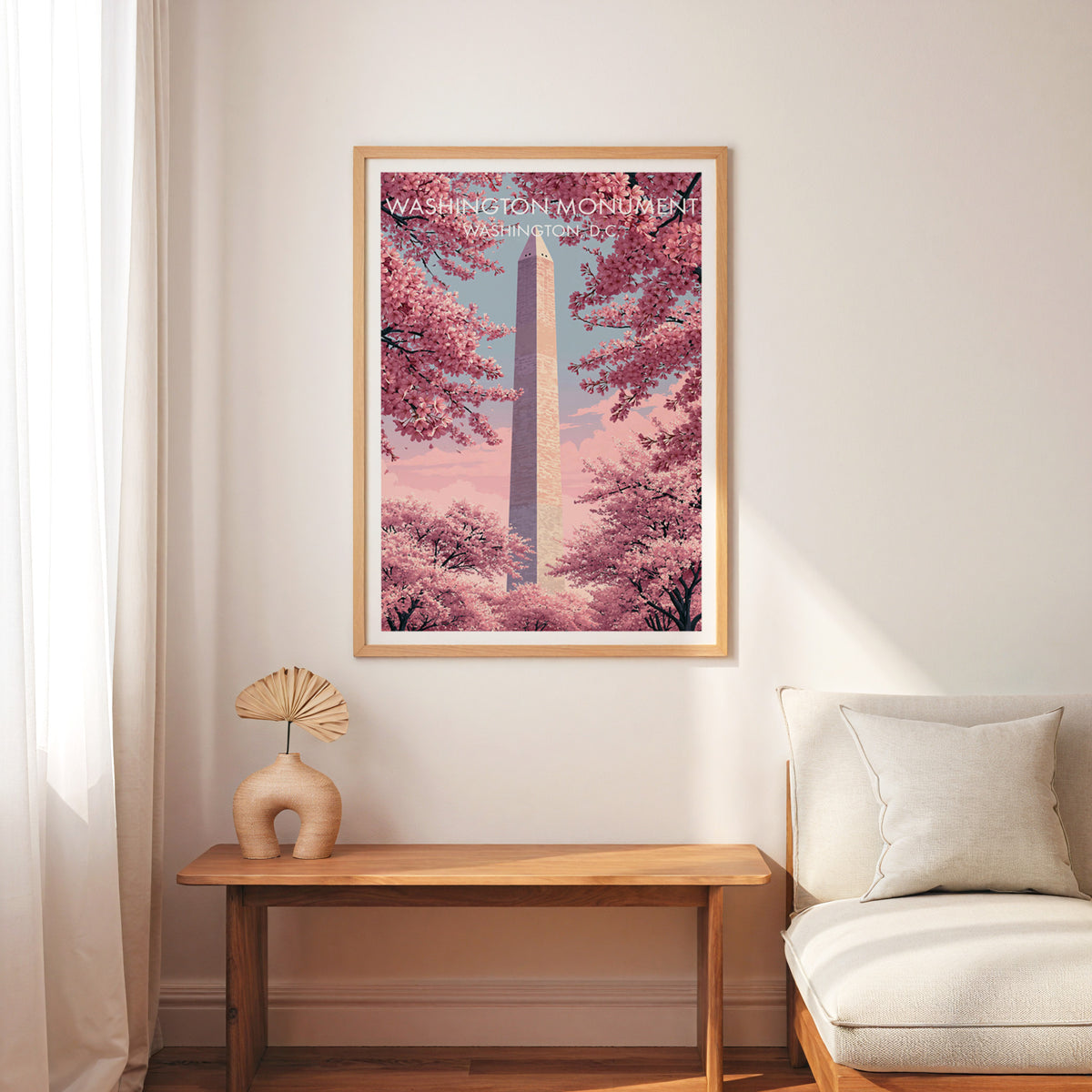 Washington Monument art print in an oak frame over a slim wooden bench, cream armchair and palm fan.