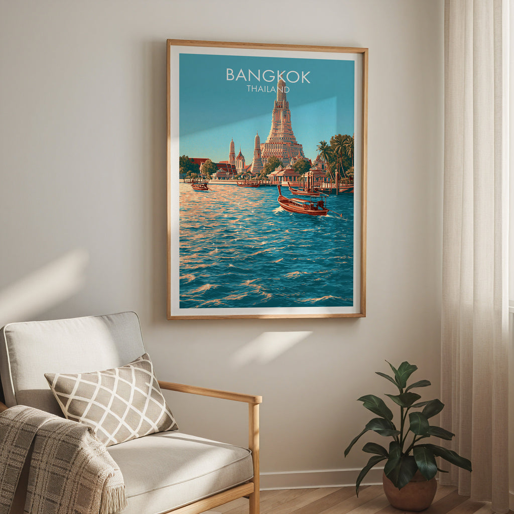 Wat Arun Bangkok Thailand travel print in a light oak frame on a living room wall beside a linen armchair