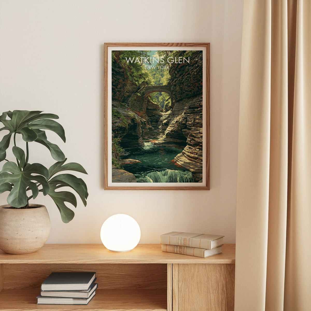 Oak-framed Watkins Glen canvas print on a beige wall above an oak console with monstera and round globe lamp.