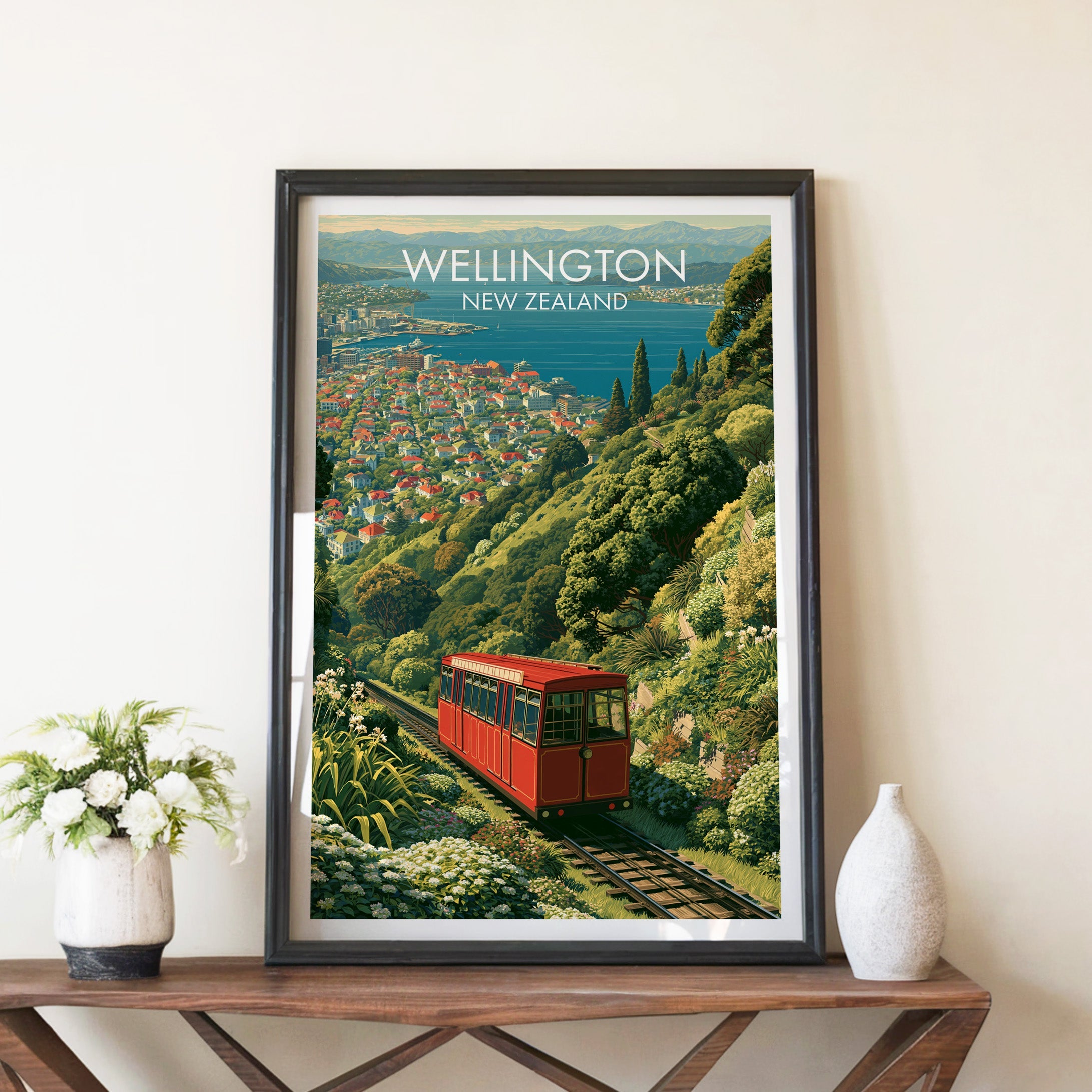 Wellington hillside poster in a black frame on a walnut console with white peonies and a stone vase