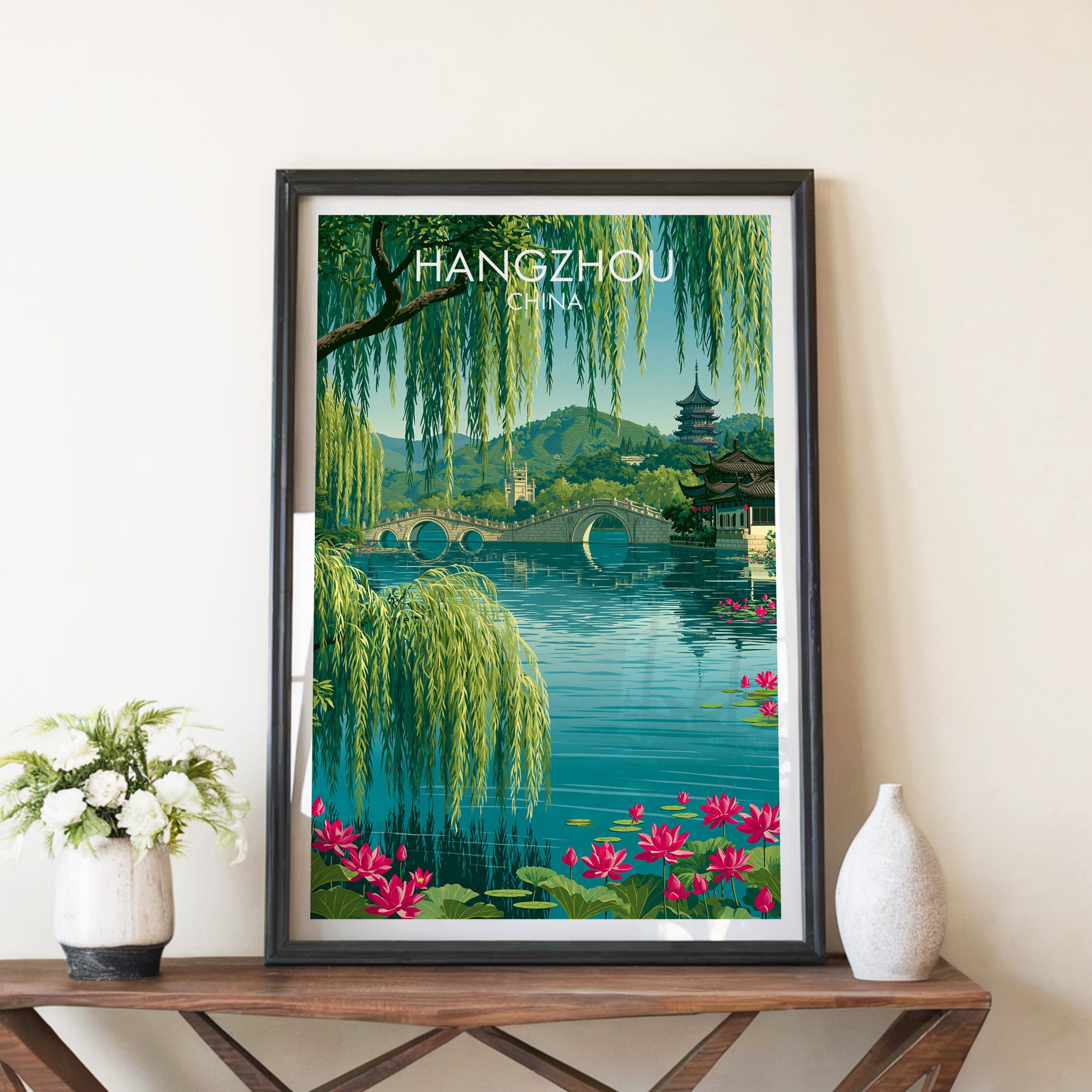West Lake Hangzhou China travel poster in a black frame on a wooden console table with white flowers