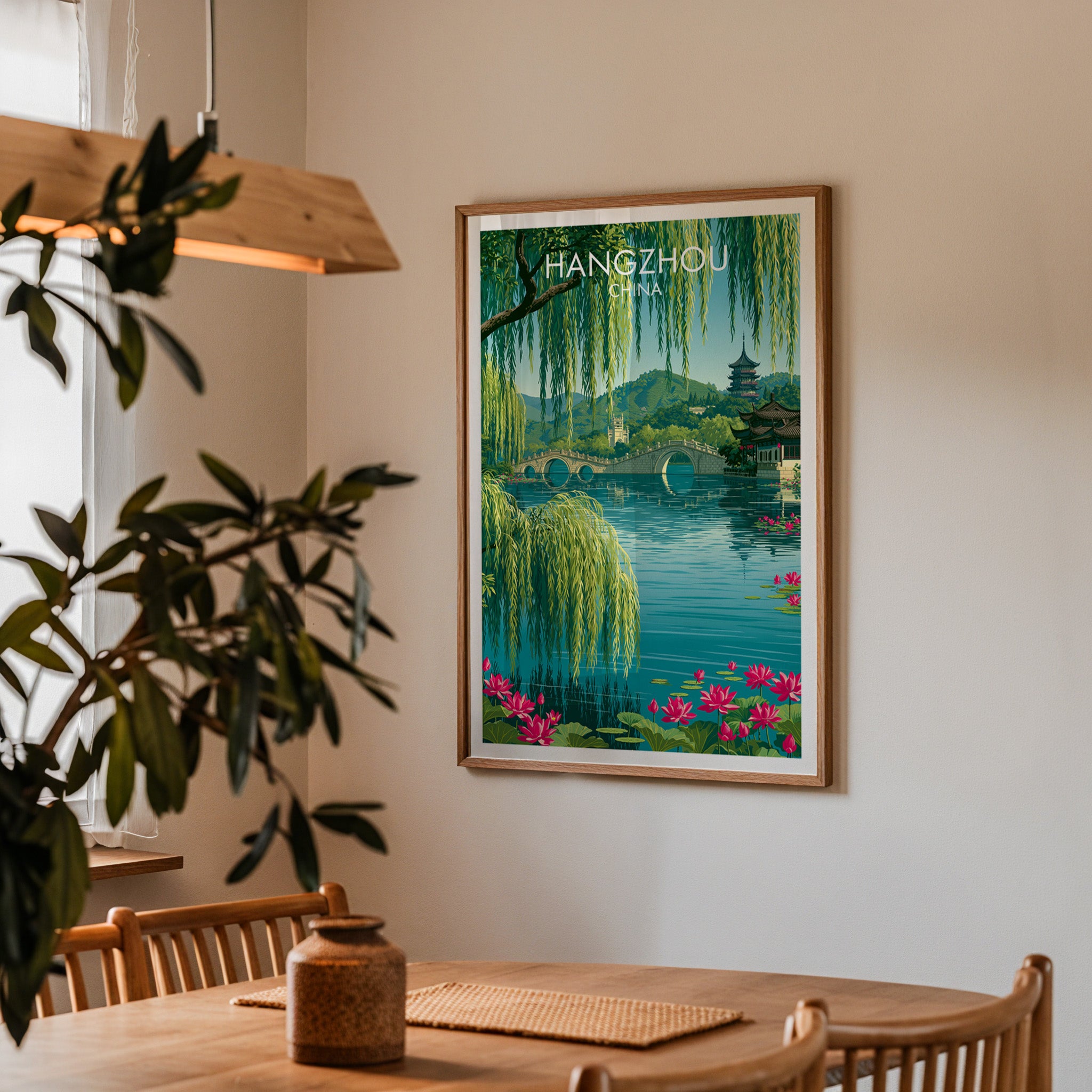 Framed West Lake Hangzhou China print on a dining room wall above an oak table in warm afternoon light