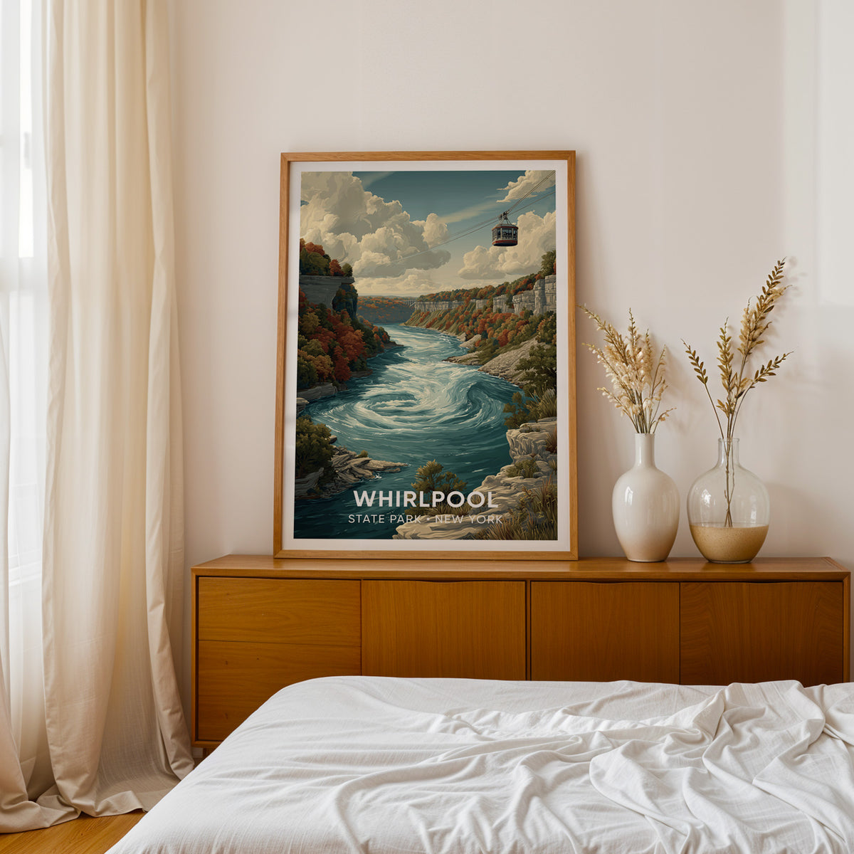 Whirlpool print in an oak frame on a teak sideboard beside a bed with dried pampas in two white vases
