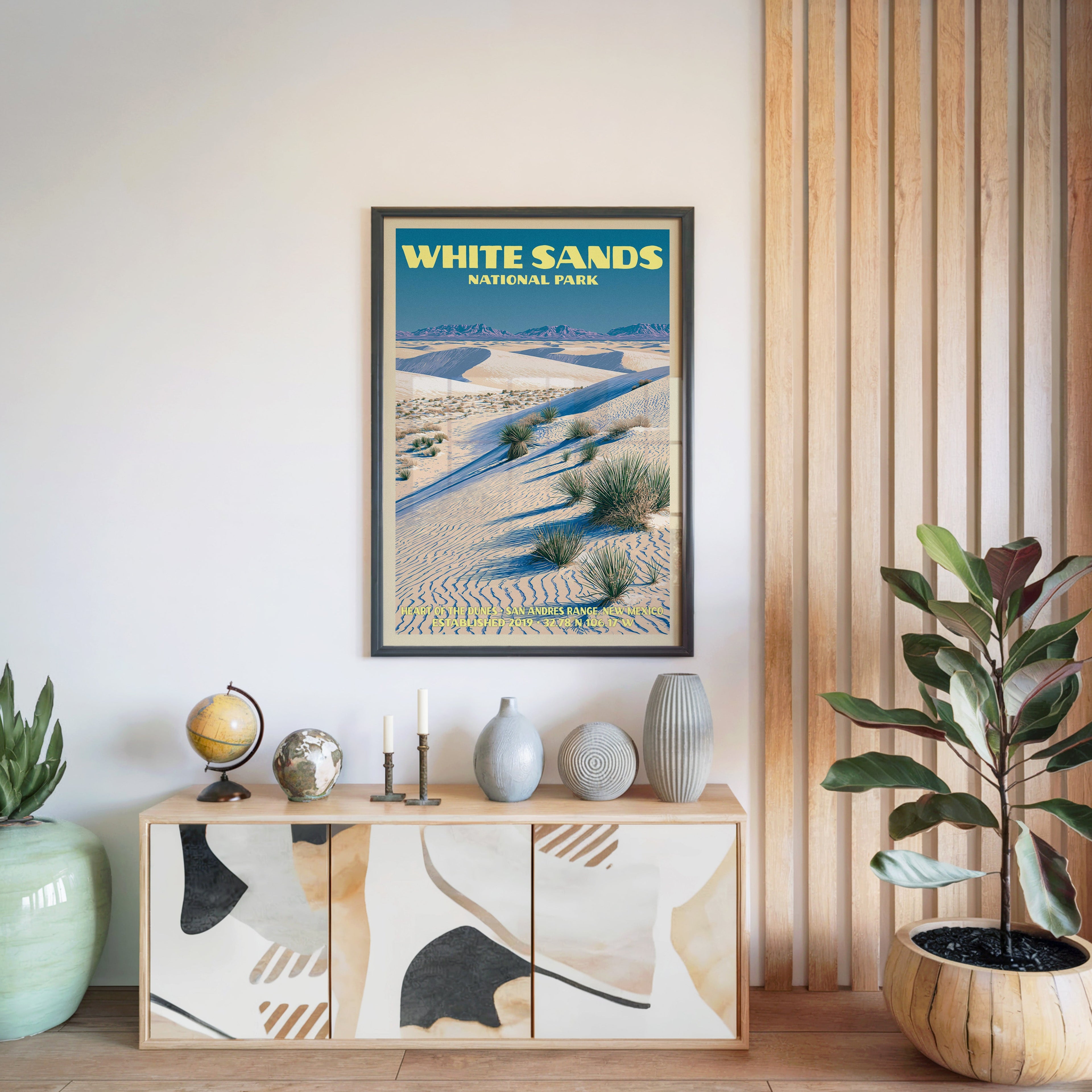 White Sands National Park poster in a black frame above a light wood sideboard beside a slatted wall panel