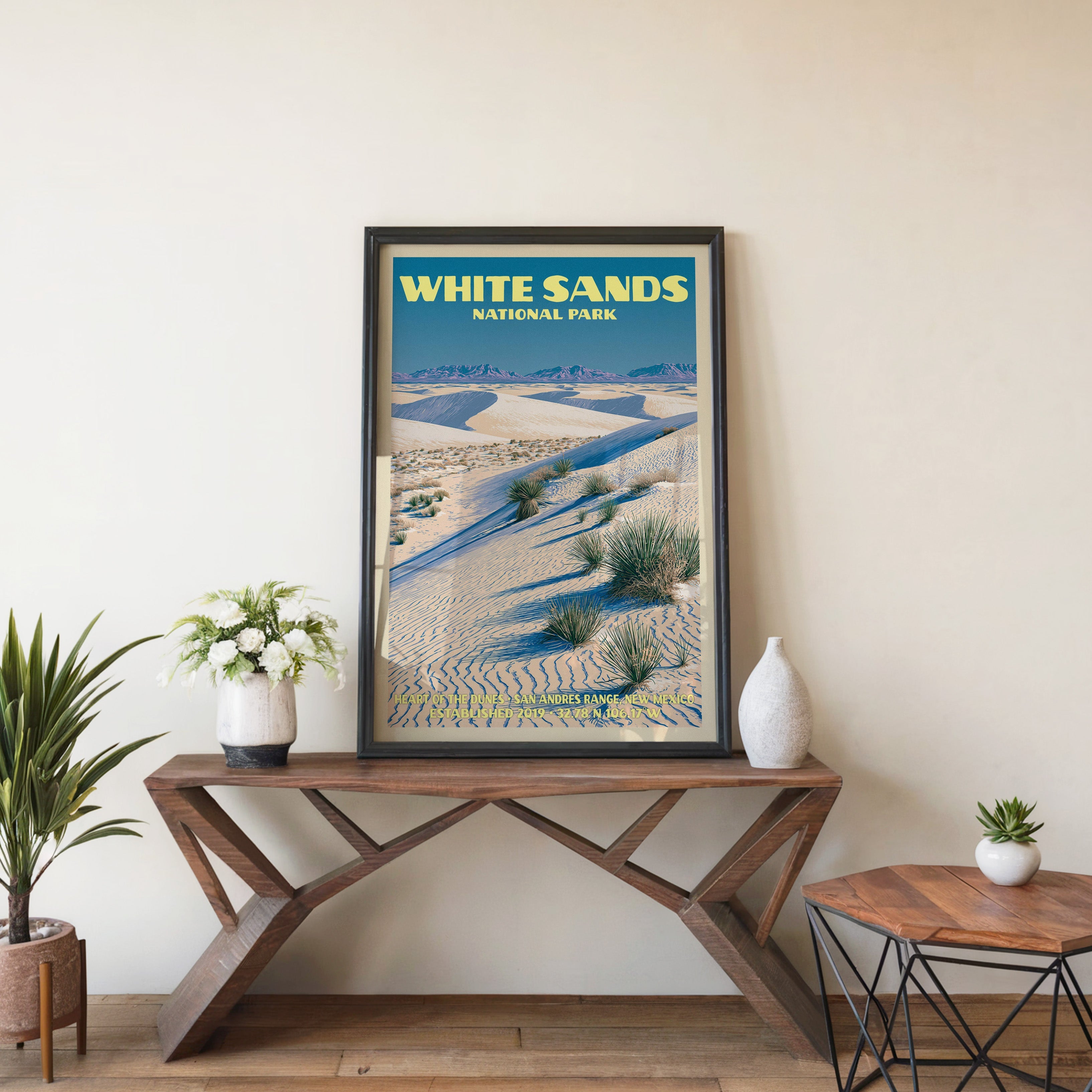 Heart of the Dunes wall art in black, leaning on a walnut console with white anemones and a ceramic vase