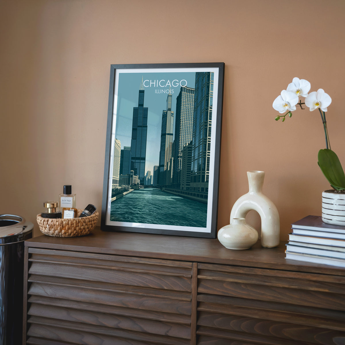 Chicago River canyon wall art in a black frame on a walnut sideboard against a terracotta wall.