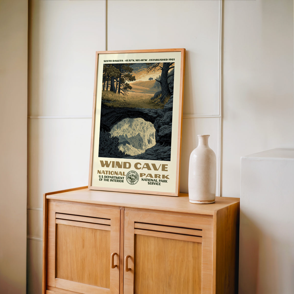 Wind Cave National Park WPA print framed in light oak on a wooden sideboard with a ceramic vase