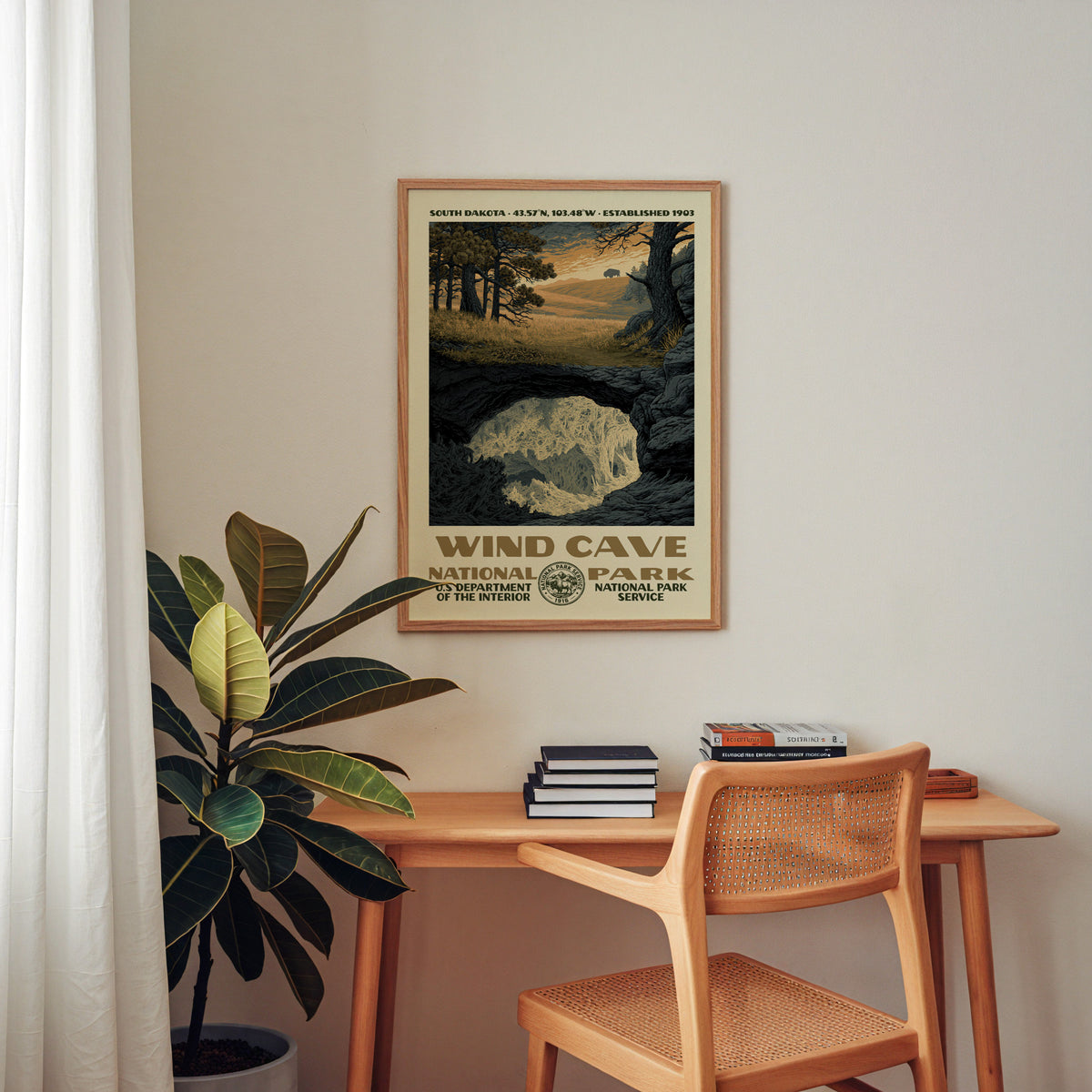 Wind Cave National Park retro poster framed above a wooden home office desk with books and plants