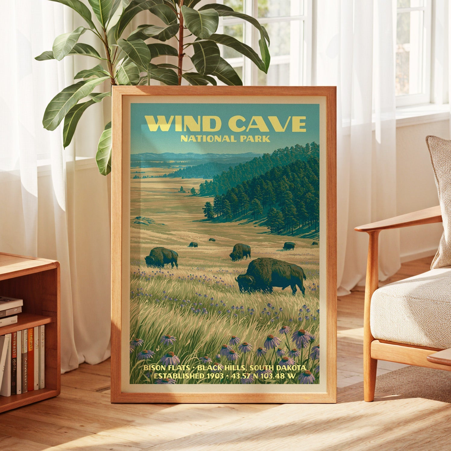 Wind Cave vintage poster in oak, leaning by a sunlit window with sheer curtains and a low bookshelf