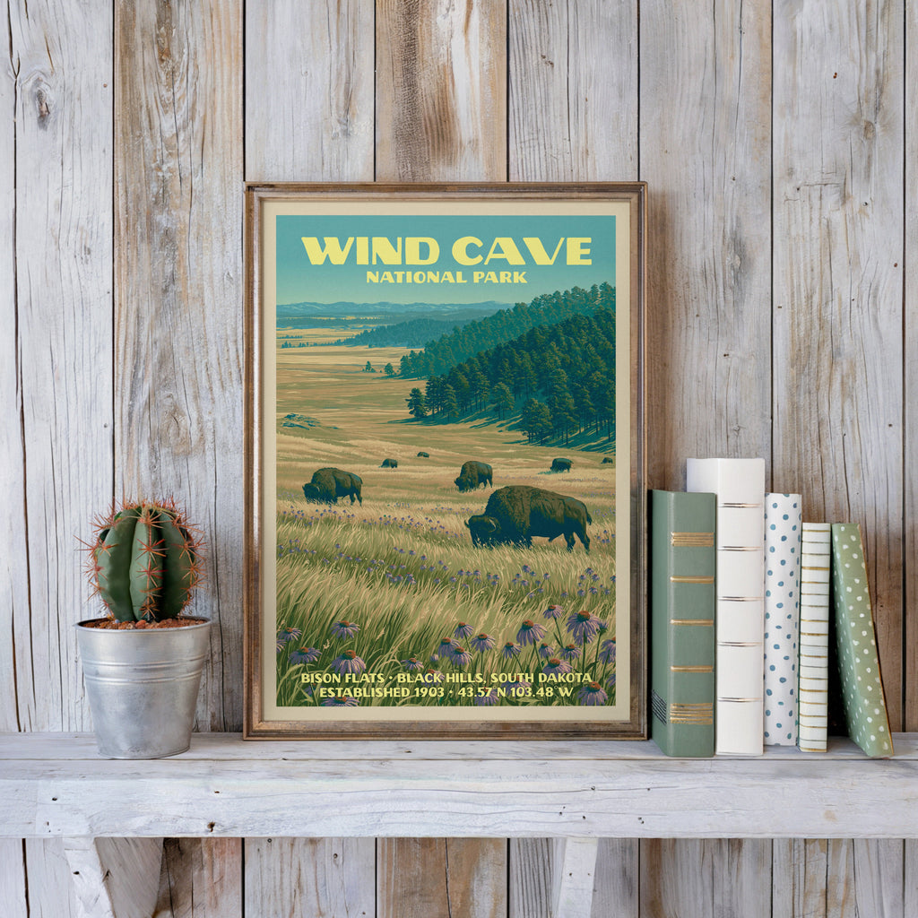 Wind Cave vintage poster in a slim gold frame on a whitewashed plank wall beside a cactus and pastel books