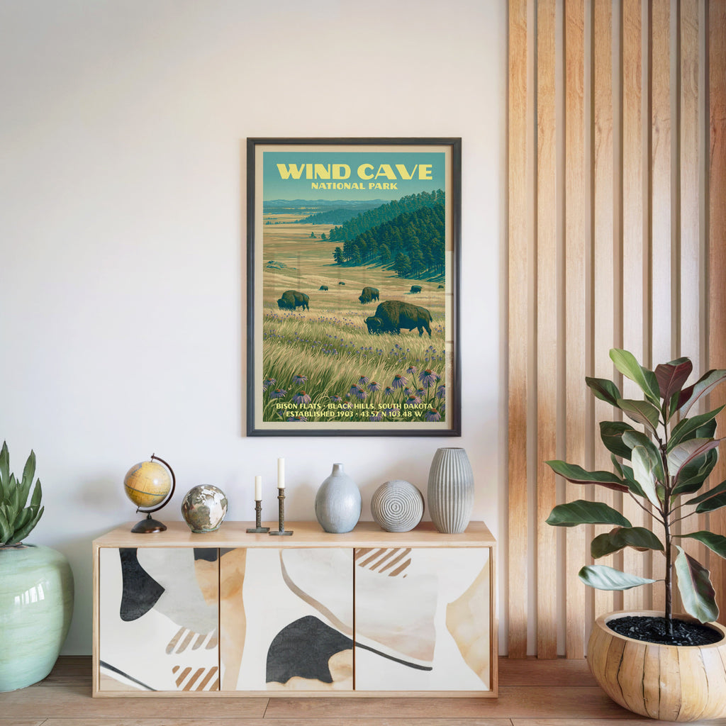 Wind Cave National Park poster in a black frame above a light wood sideboard beside a slatted wall panel
