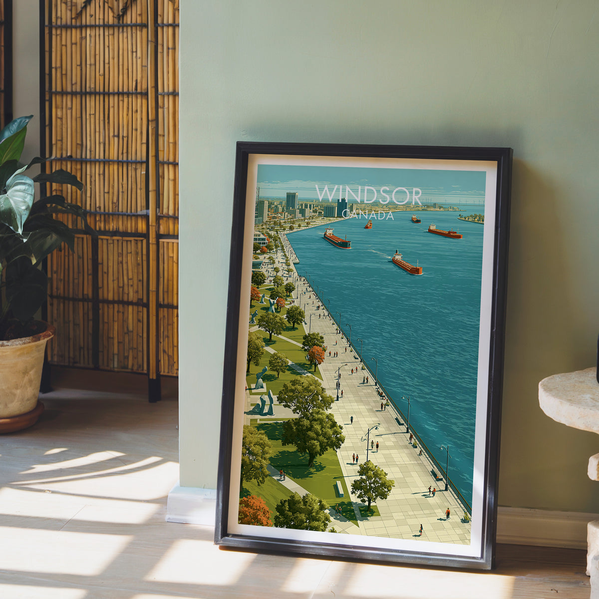 Windsor Ontario travel print in a black frame on the floor by a sage wall and bamboo screen