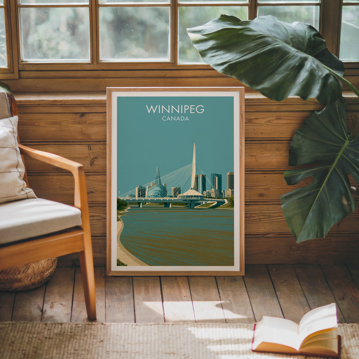 Winnipeg Canada travel poster in an oak frame against a pine cabin wall beside a monstera