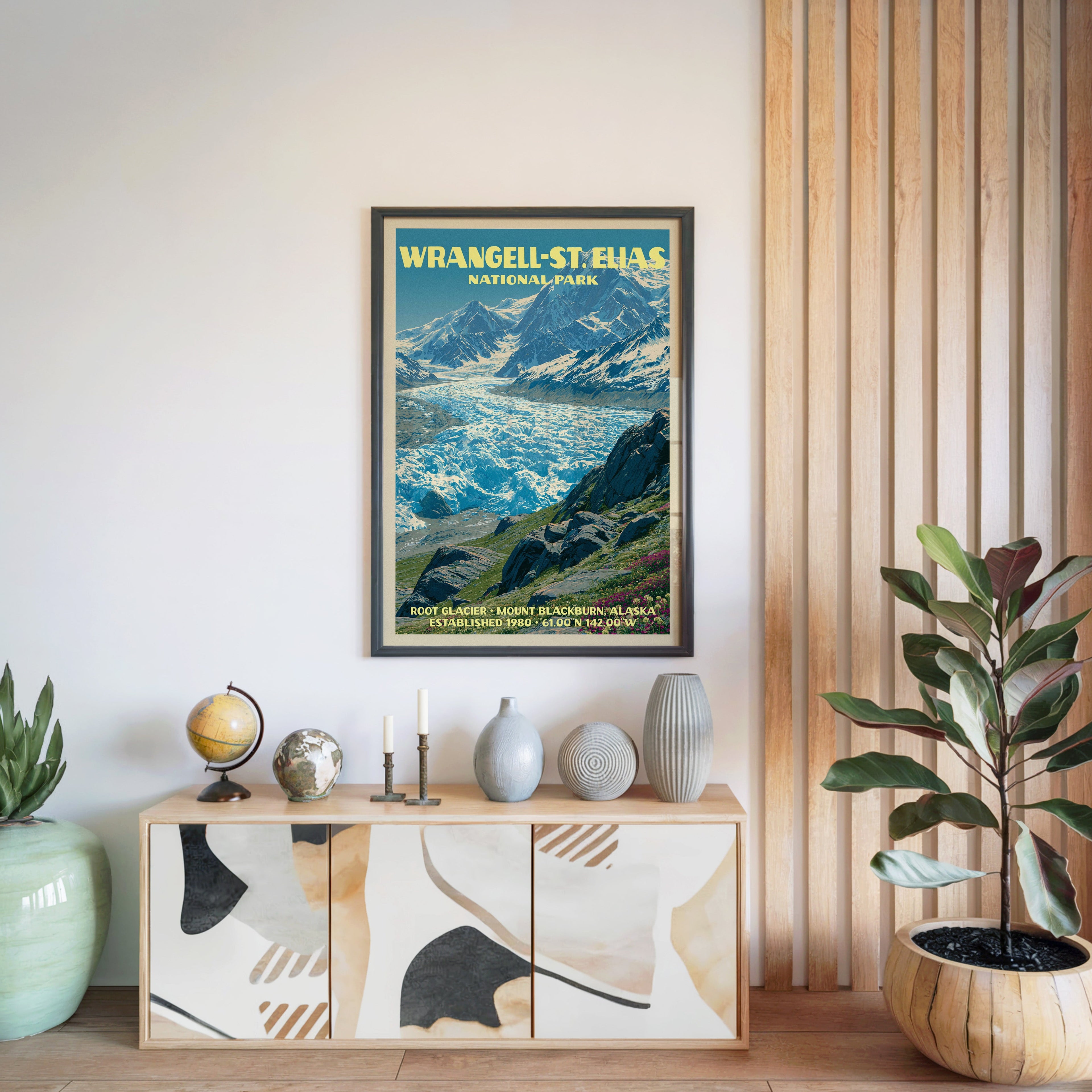 Wrangell–St. Elias National Park poster in a black frame above a light wood sideboard beside a slatted wall panel