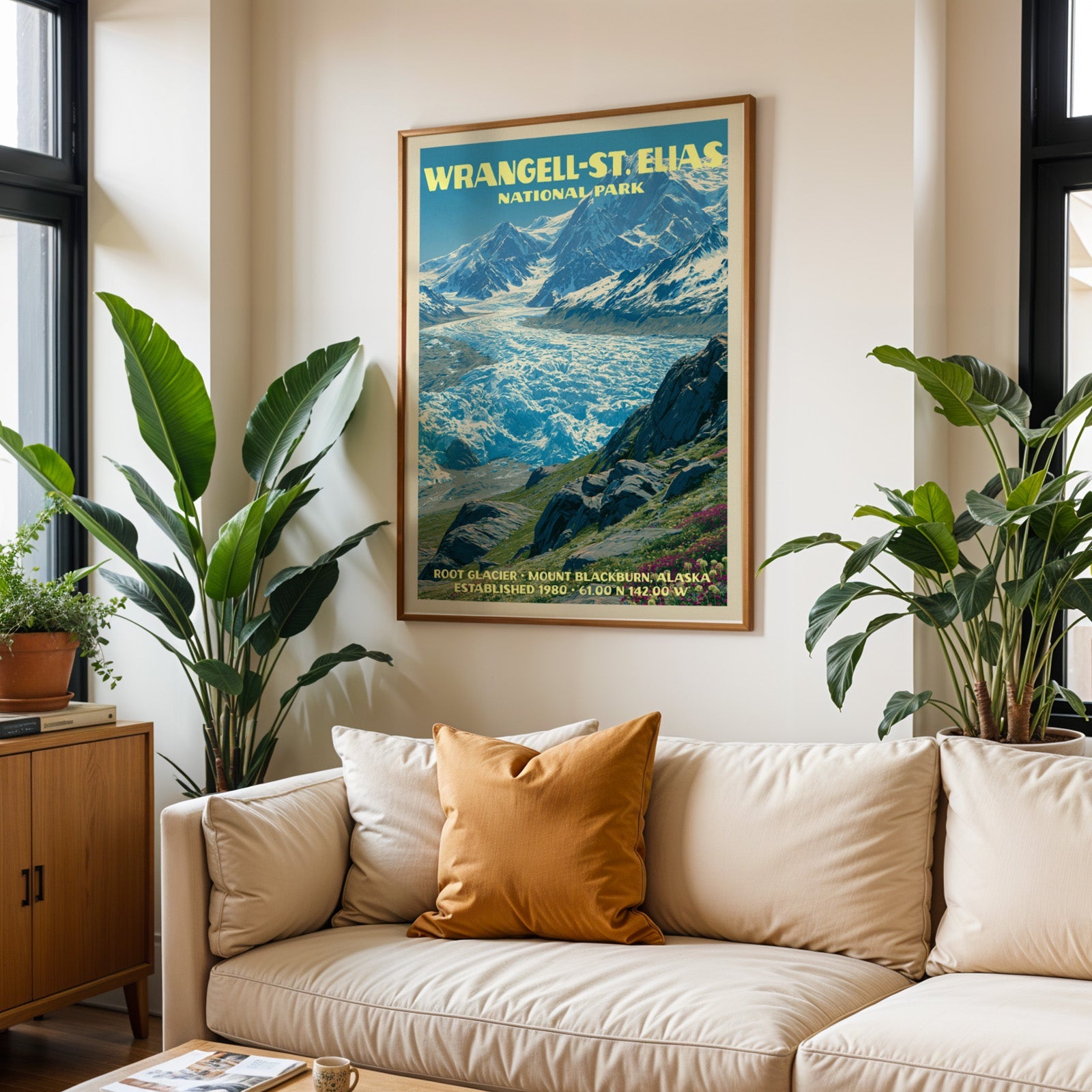 Wrangell–St. Elias vintage travel print in oak above a cream sofa with a rust cushion and tall tropical plants