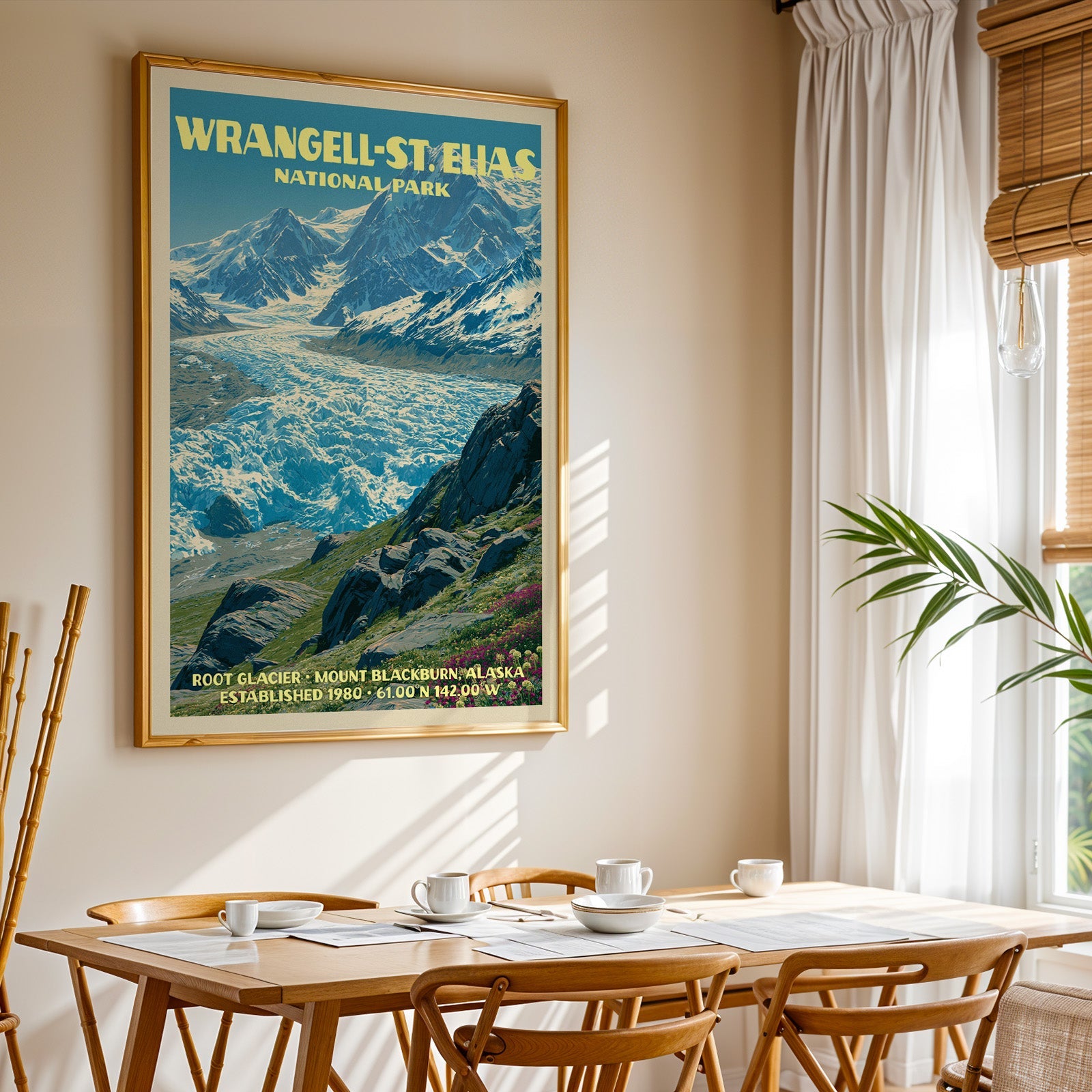 Wrangell–St. Elias National Park print in gold above a light oak dining table by a sheer-curtained window