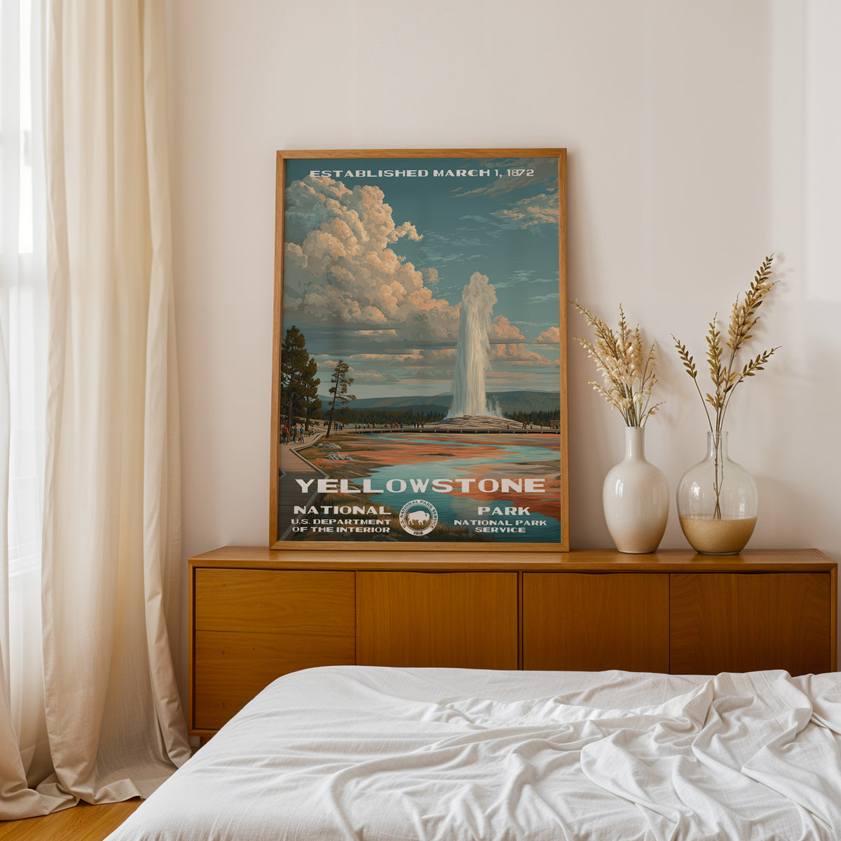 Yellowstone National Park retro poster above a walnut sideboard in a bright linen bedroom