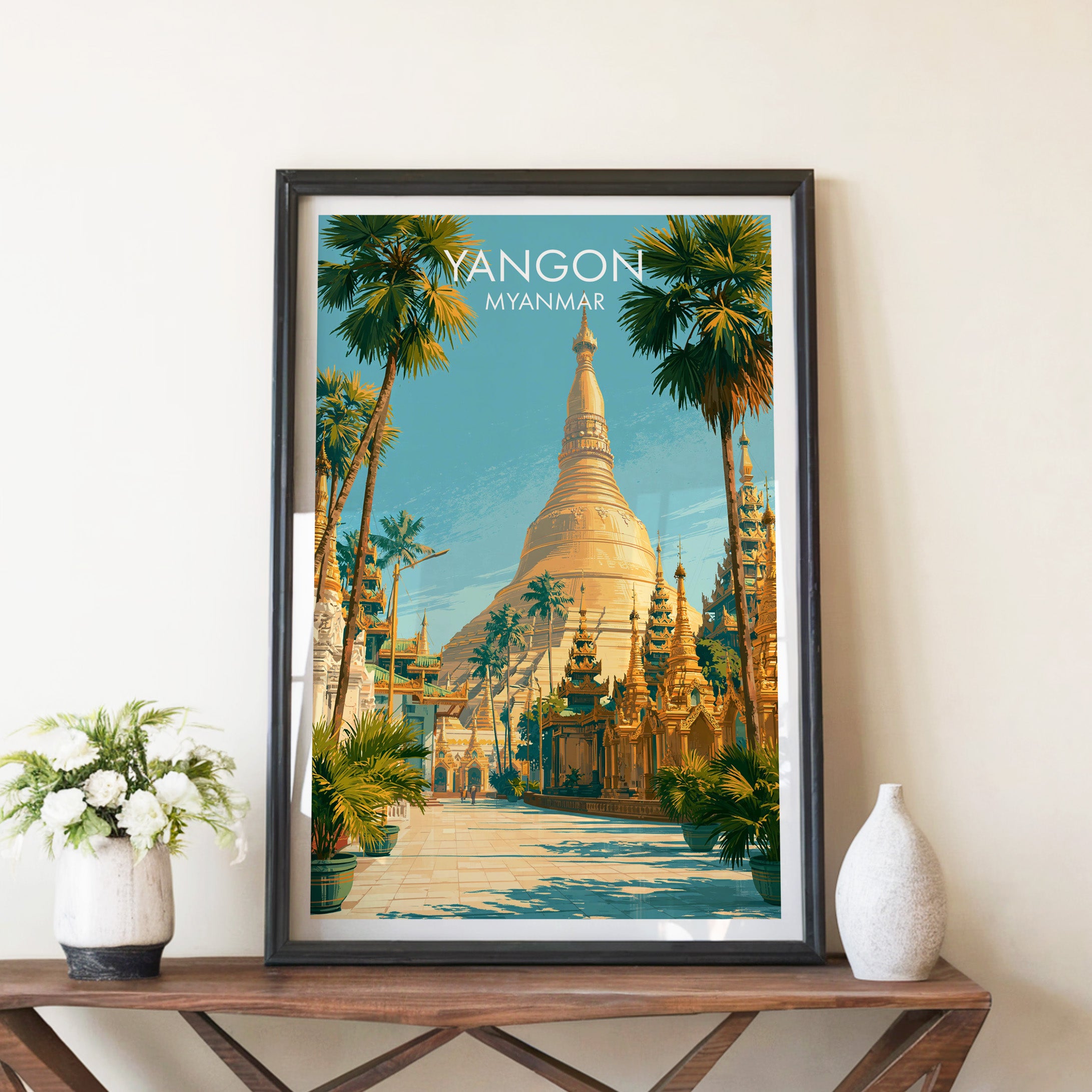 Yangon Myanmar travel poster in a black frame on a wooden console table with white flowers
