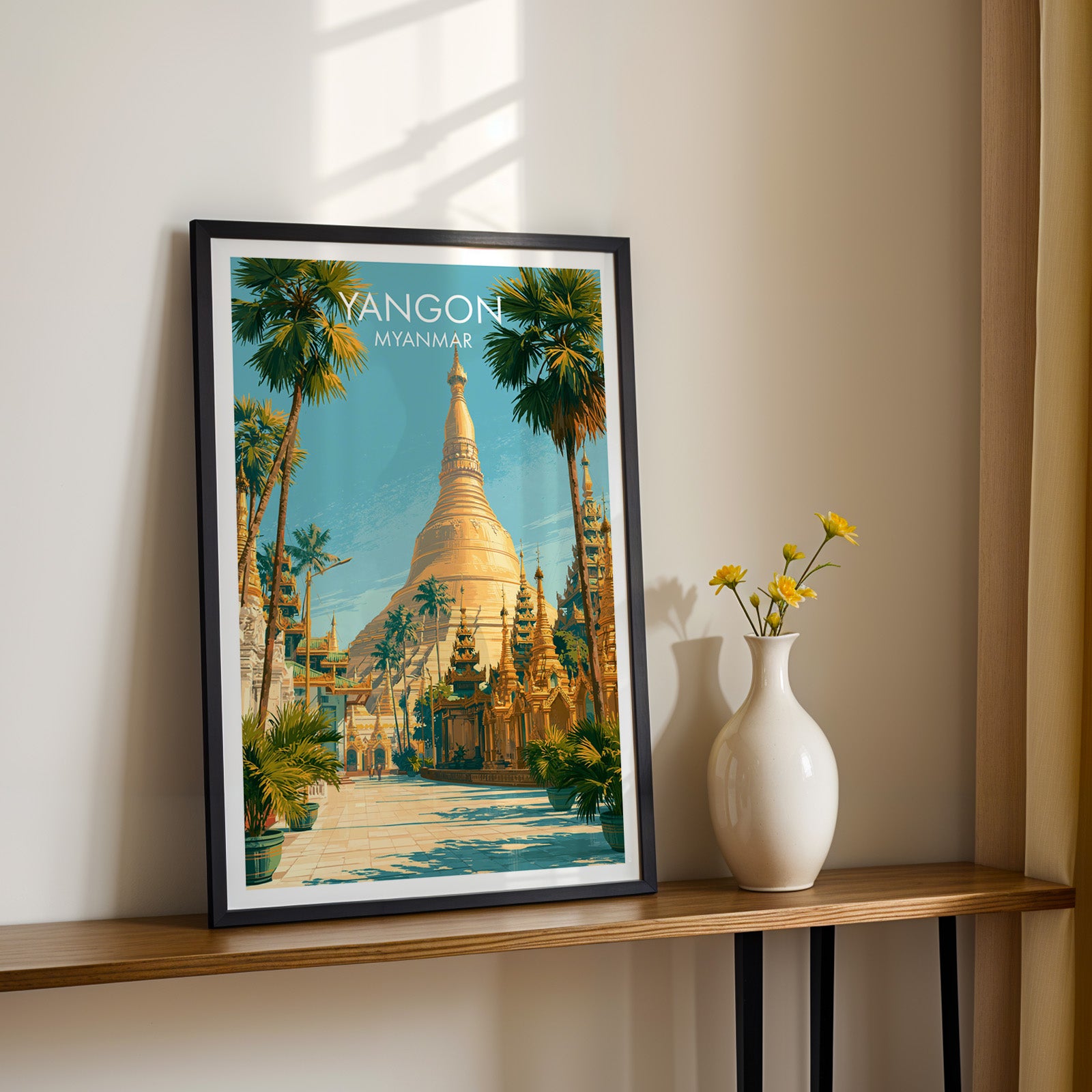 Black framed Yangon Myanmar print on a narrow hallway console in sunlight, styled with yellow flowers