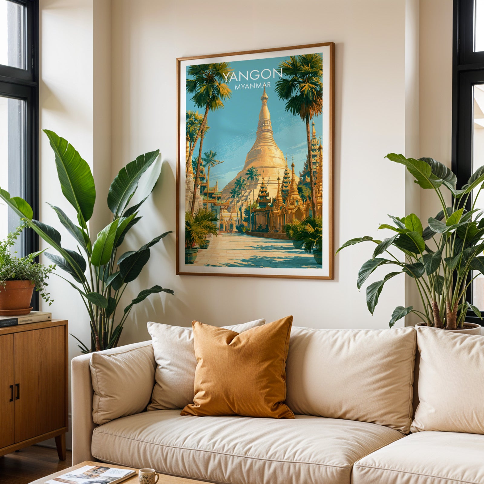 Framed Yangon Myanmar wall art hanging above a cream sofa in a bright living room with tropical plants