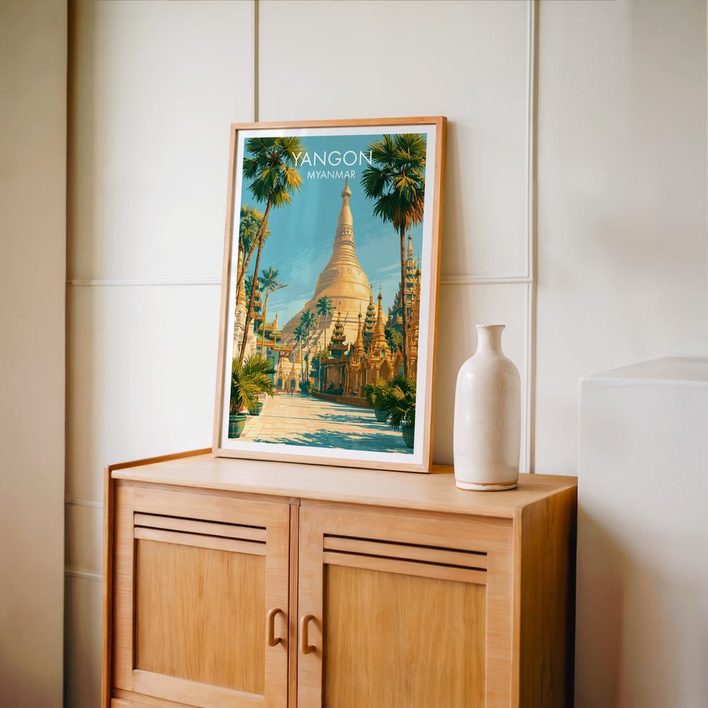 Small Yangon Myanmar travel poster in an oak frame on a mid-century sideboard with a ceramic vase